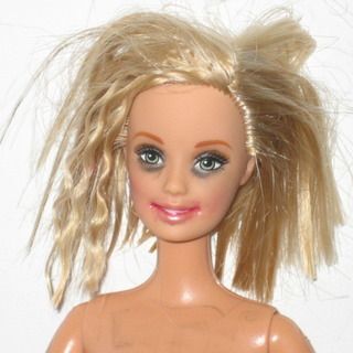 A barbie doll with messed up hair and makeup