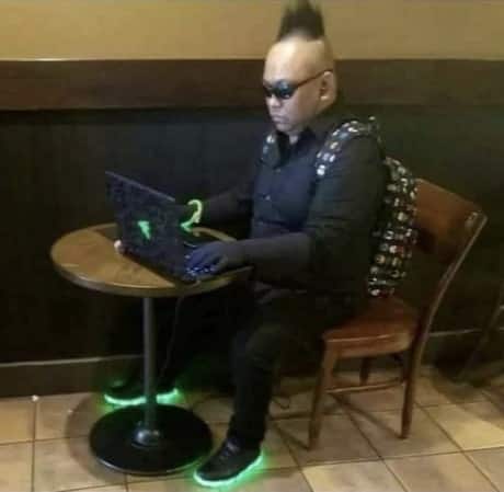 Guy with spiky hair on a laptop in coffee shop