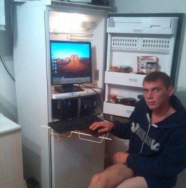 A guy working with his computer in his fridge