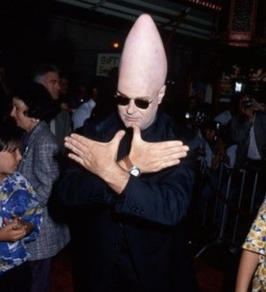 A conehead making the Wu-Tang sign