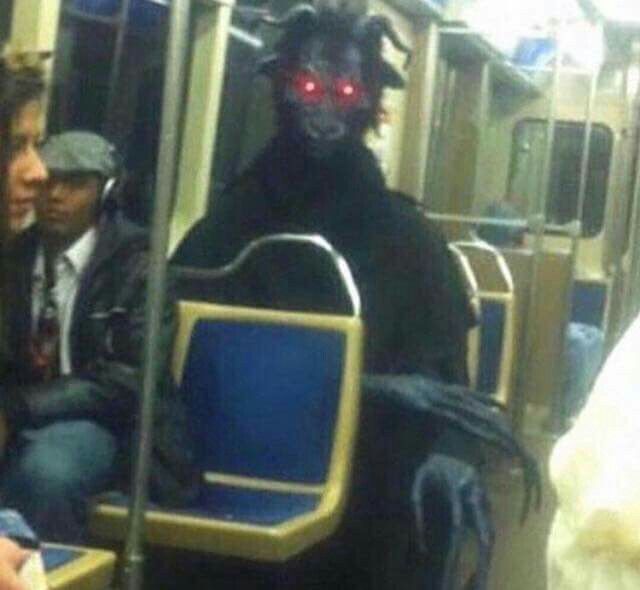 A demon costume riding on the subway