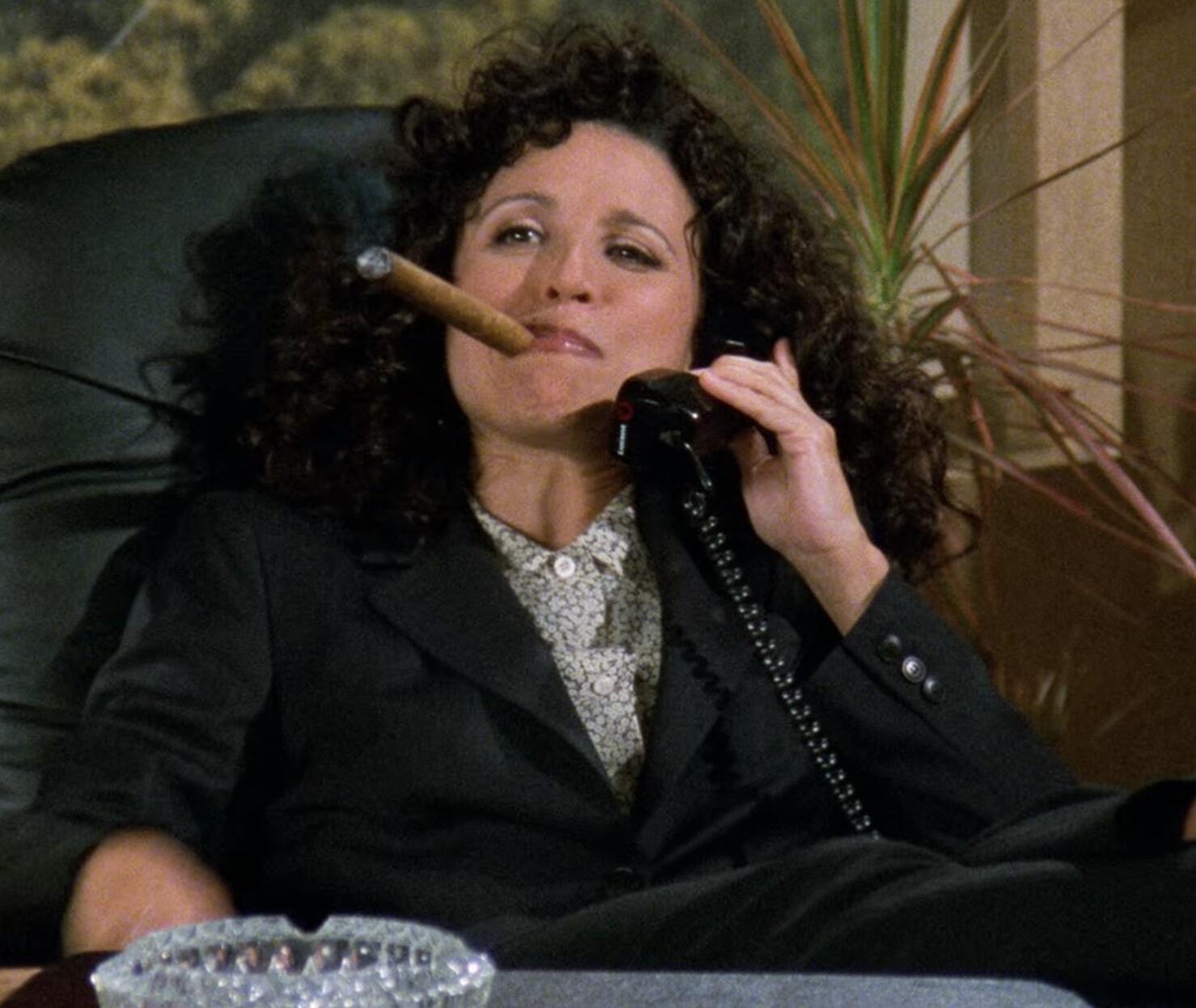 Elaine from Seinfeld holding a phone with a cigar in her mouth