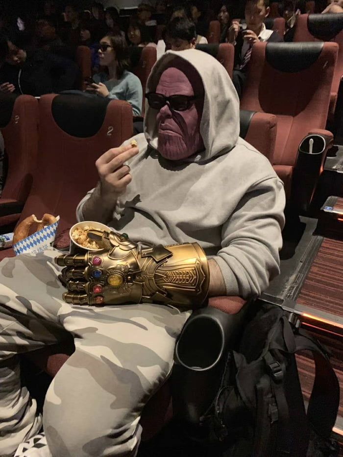 Kid eating popcorn with a Thanos mask on