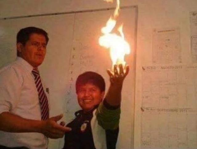 Kid holding up fire in front of his teacher