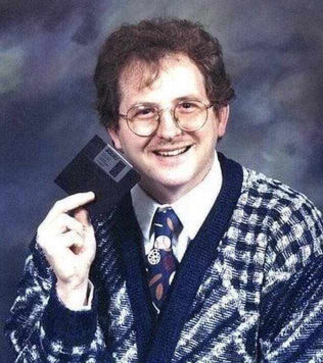 Guy posing for a picture with a floppy disk