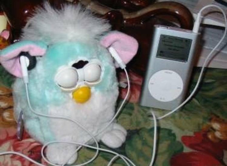 Furby closing its eyes with iPod Mini headphones on