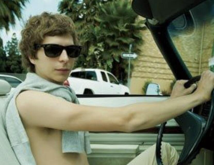 Michael Cera driving a car shirtless