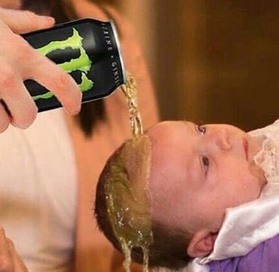 A baby getting baptized with a Monster energy drink