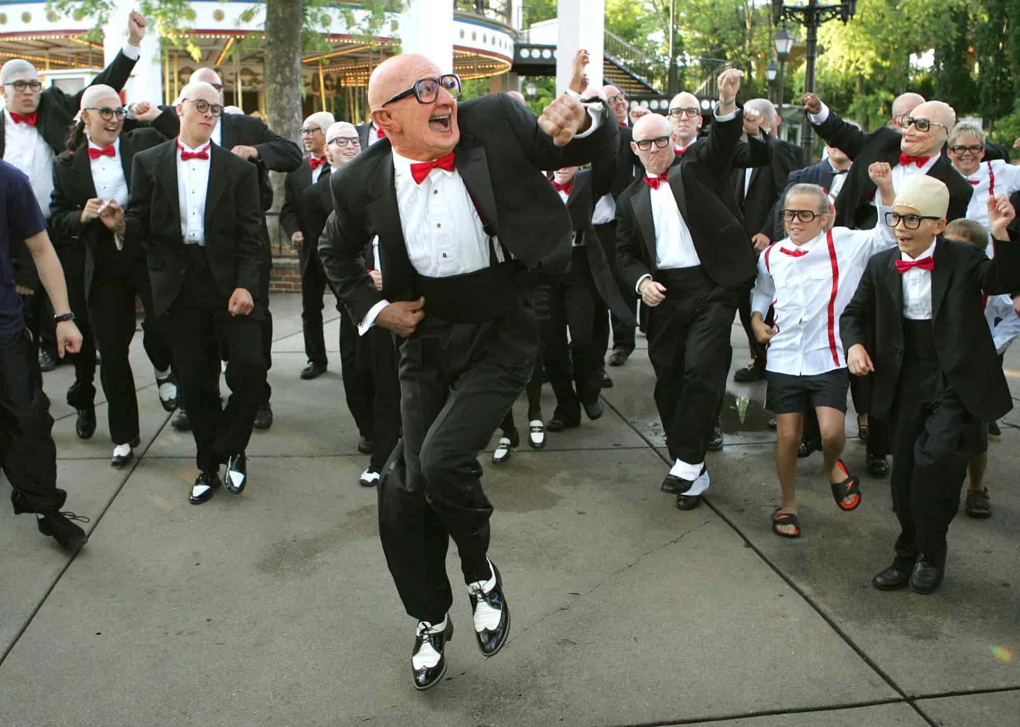 The old Six Flags man dancing with a bunch of people dressed up like him