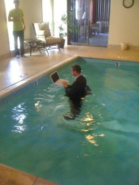 Person using a computer in a pool