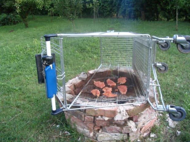 Someone using a shopping cart turned on its side to grill meat