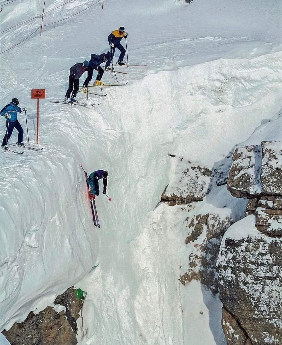 Skier going over a steep ledge